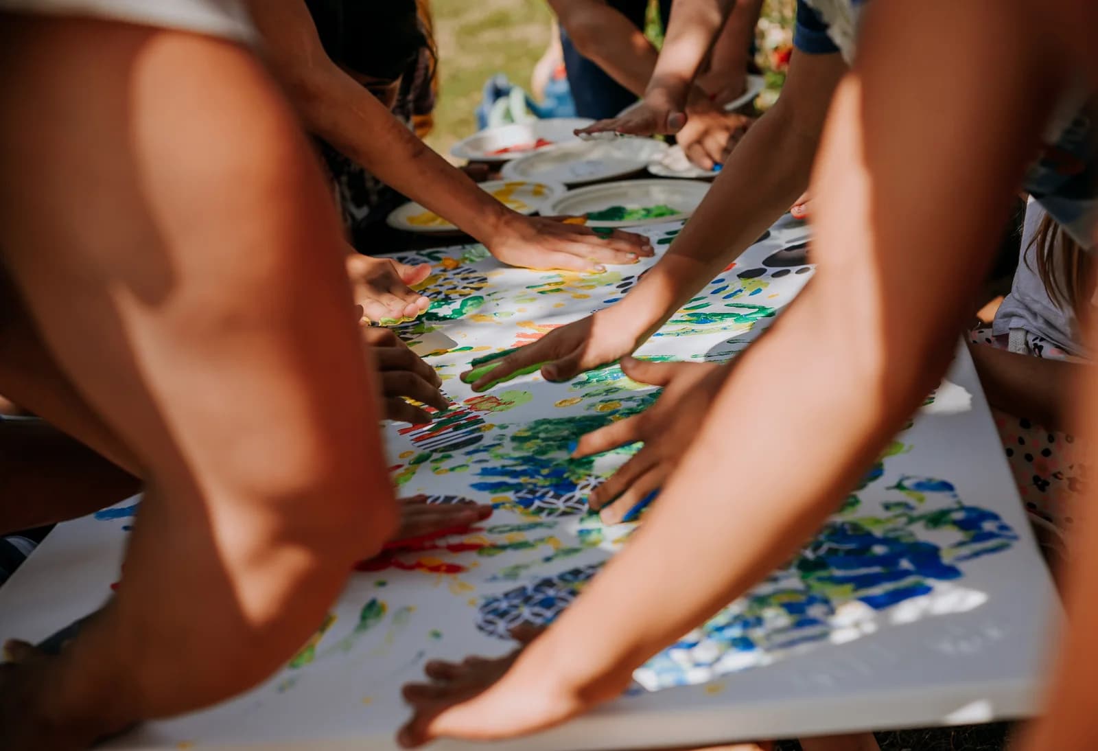 Copiii și voluntarii creează împreună o pictură colorată